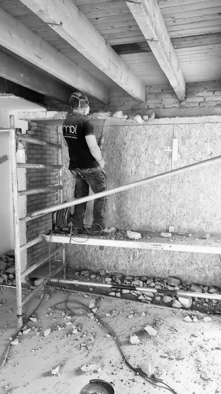 MIBI-vakman bij sloop- en breekwerk aan een binnenmuur — klein bouwwerk in een woning